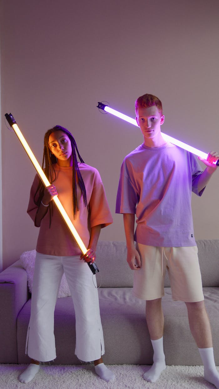 Stylish couple with LED lights pose in a modern indoor setting, creating a vibrant and artistic atmosphere.